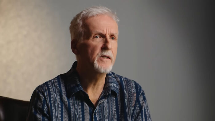 James Cameron, a silver-haired man with a goatee, wearing a patterned blue shirt, representing rude celebs.