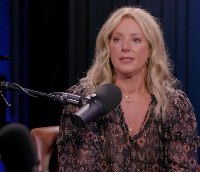 A blonde woman in a patterned blouse speaks into a microphone, sharing insights on rudest celebs.