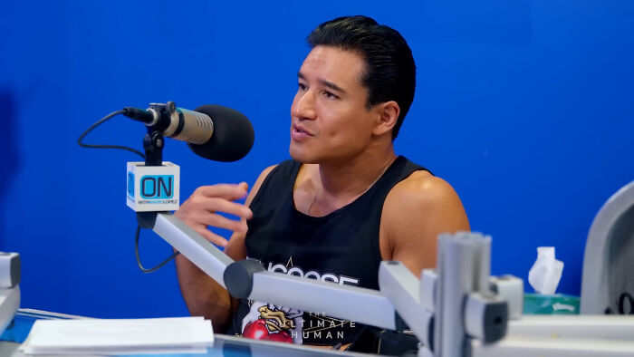 Male celebrity, wearing a black tank top, speaking into a microphone in a studio setting. Some celebs can be rude.