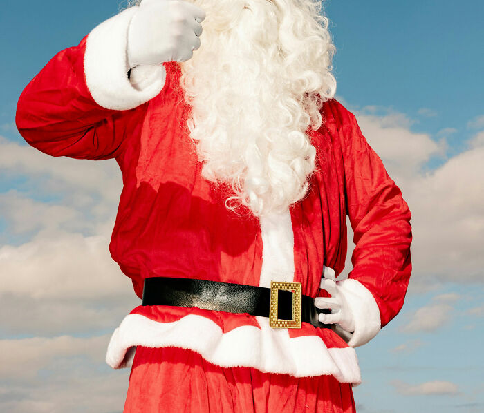 Person dressed as Santa Claus in a red suit with a white beard, symbolizing loving and amazing moms stories.