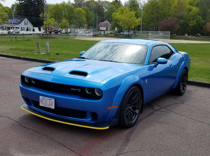 Blue muscle car parked on a street, related to entitled woman damaging guy&rsquo;s car and child custody issues.