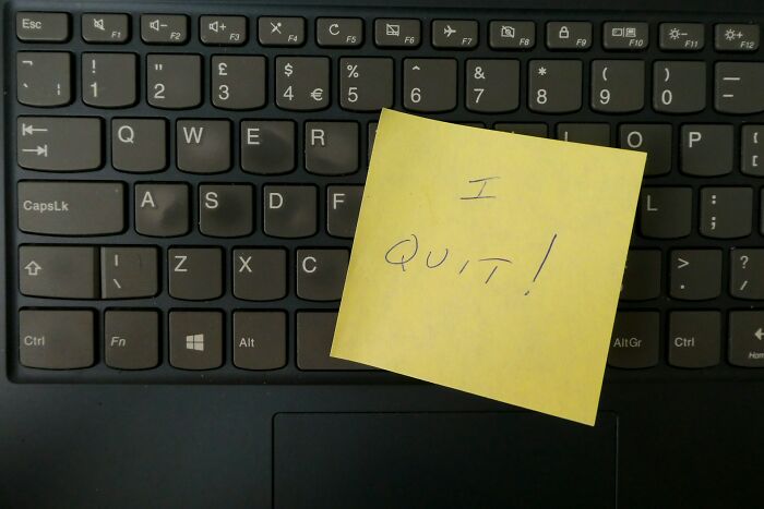 Yellow sticky note with I quit written on a black laptop keyboard representing wild times employees quitting jobs immediately.