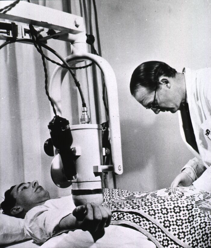 Patient undergoing treatment with a vintage medical device from the past demonstrating early healthcare technology.