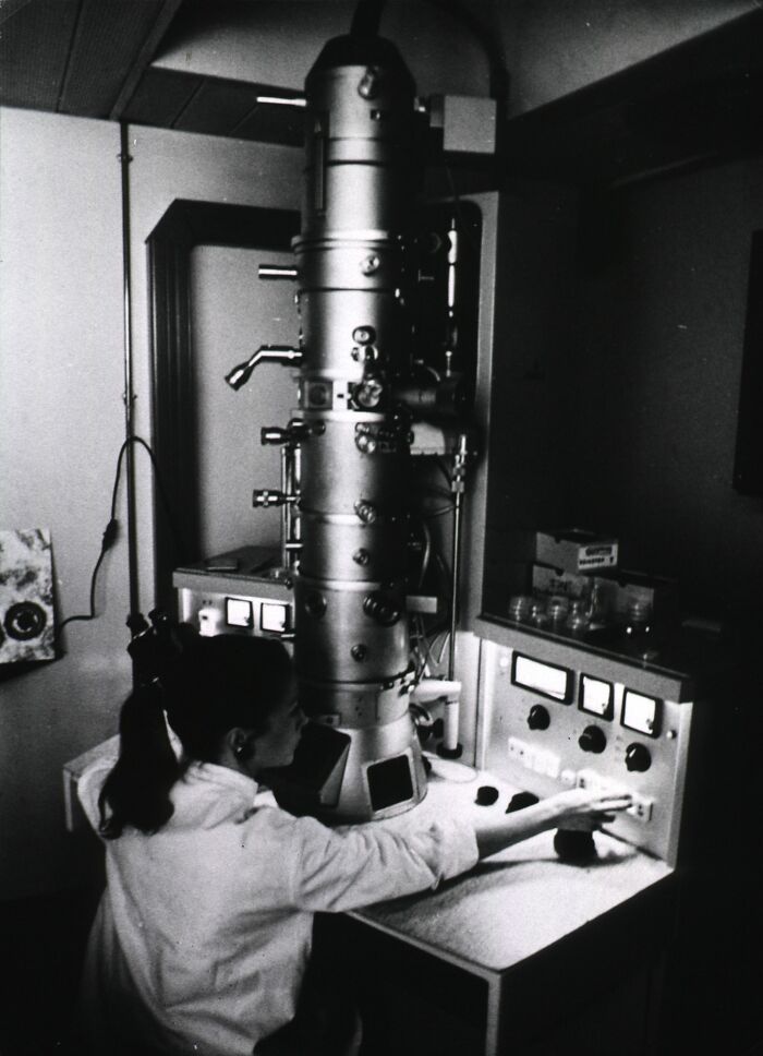 Woman operating a large vintage medical device from the past, illustrating historical medical devices and healthcare evolution.