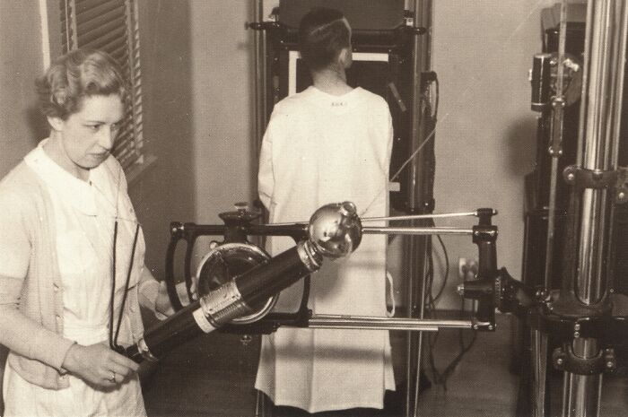 Vintage medical device from the past used in healthcare, showing early diagnostic equipment and nurse operating it.