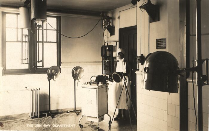 Vintage medical devices and equipment in an early 20th century healthcare room with nurse and sunlight exposure tools