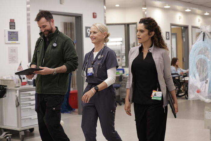 Three cast members of The Pitt walk through a hospital hallway, highlighting major cast shake up before season 2 finale.
