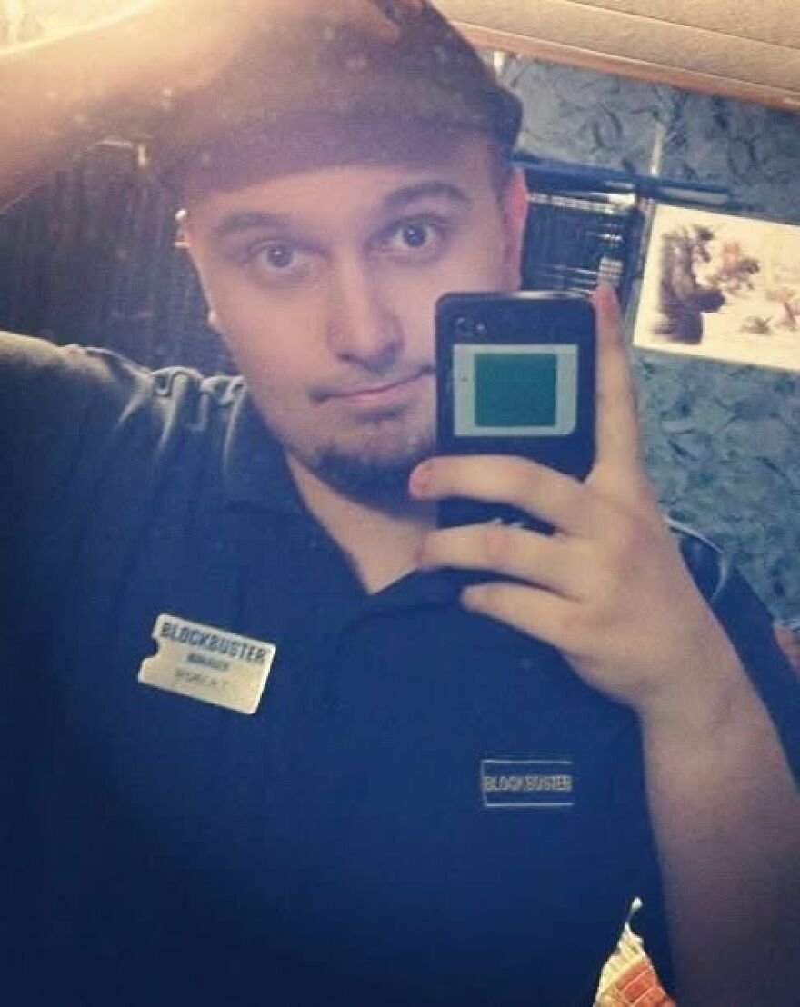 A Blockbuster employee takes a selfie, evoking nostalgia and a trip down memory lane.