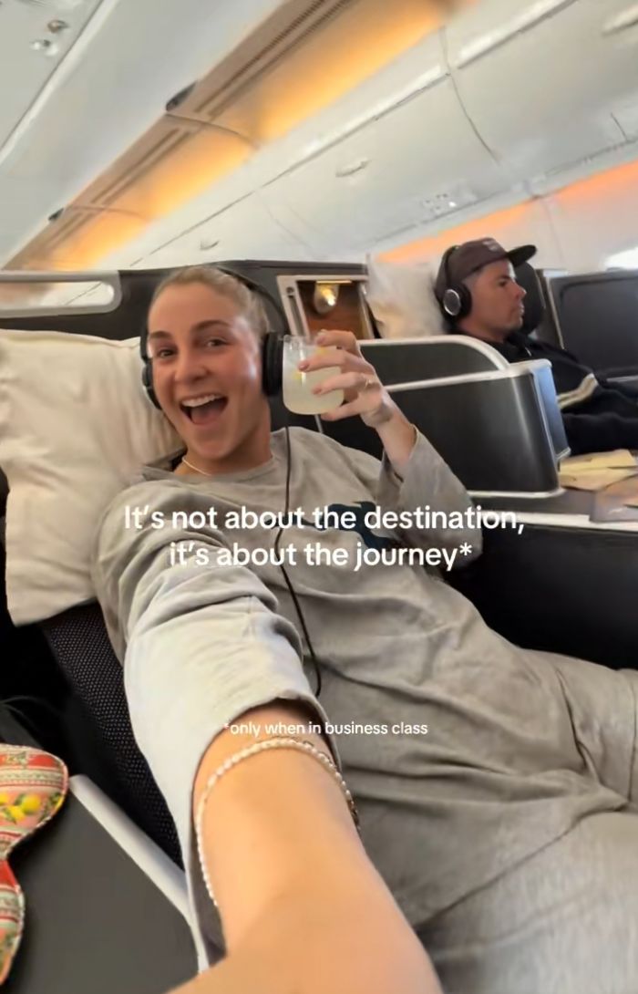 Mulher usando fones de ouvido sorrindo e segurando uma bebida, ilustrando uma história bizarra de sintomas de gravidez que surpreende os internautas. Mulher usando fones de ouvido sorrindo e segurando uma bebida, ilustrando uma história bizarra de sintomas de gravidez que surpreende os internautas.