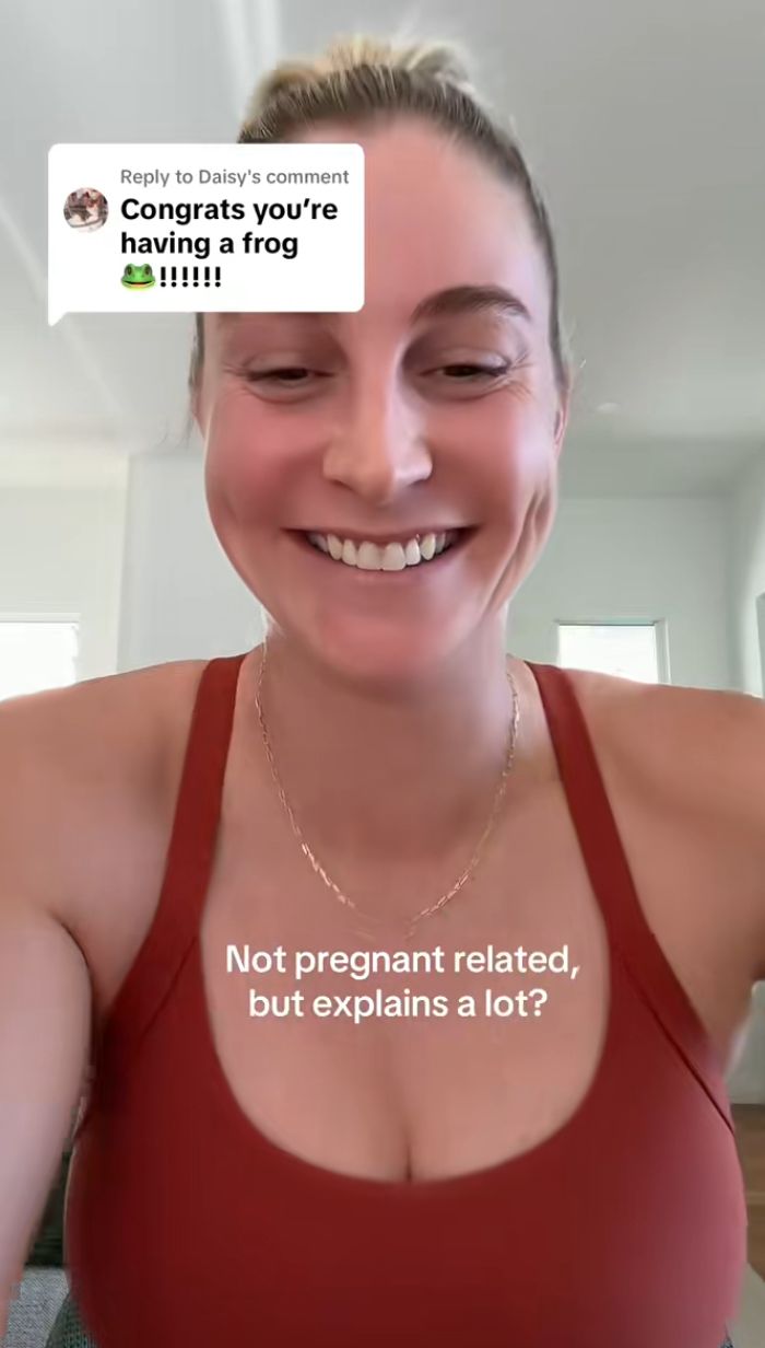 Mulher sorridente compartilhando um sintoma bizarro de gravidez que assusta os internautas em um ambiente interno casual. Mulher sorridente compartilhando um sintoma bizarro de gravidez que assusta os internautas em um ambiente interno casual.