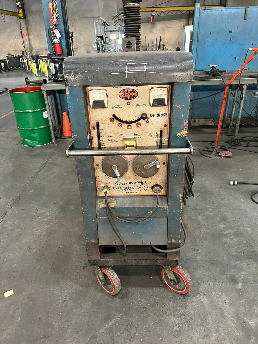 Old welding machine in a workshop with dial gauges and cables, showing a face-like pattern from pareidolia.