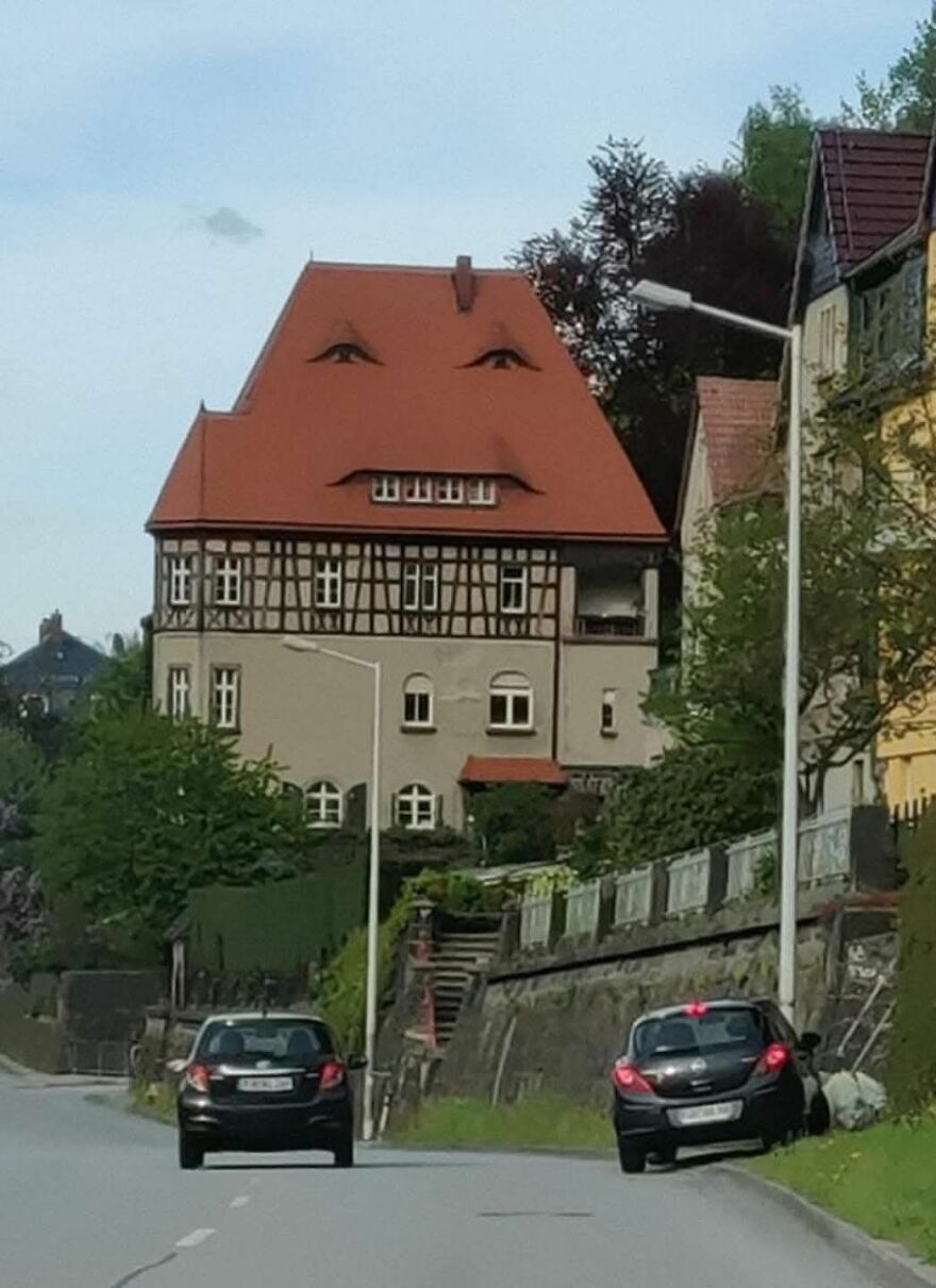 House roof appears to have a face with eyes and a mouth, an example of pareidolia seen from the street.