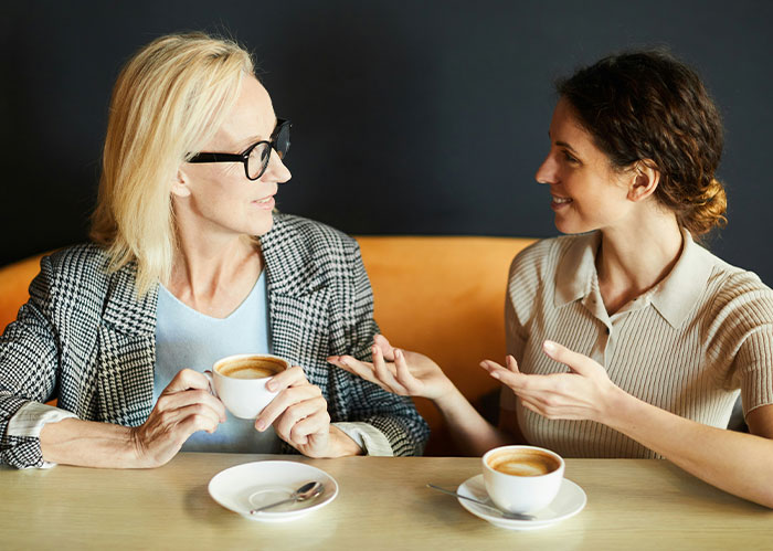 Two women having coffee, gesturing while talking. One needs better friends after a realization.