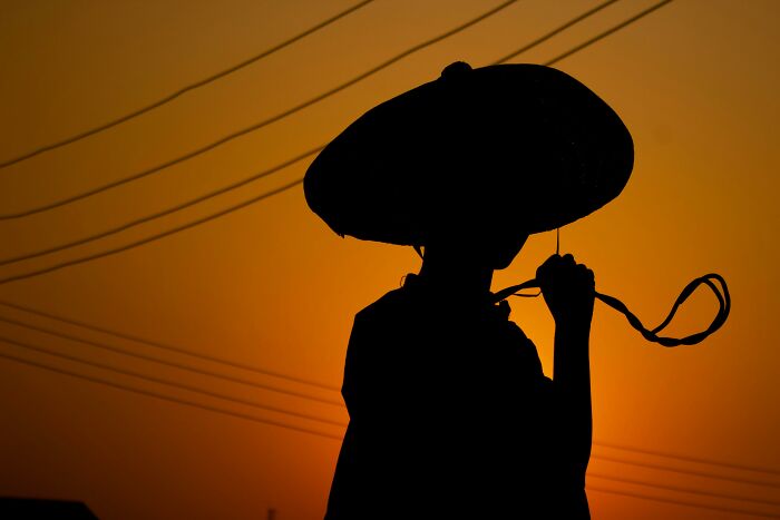 Silhouette of a film character wearing a large hat at sunset, challenging your sharp movie memory skills.