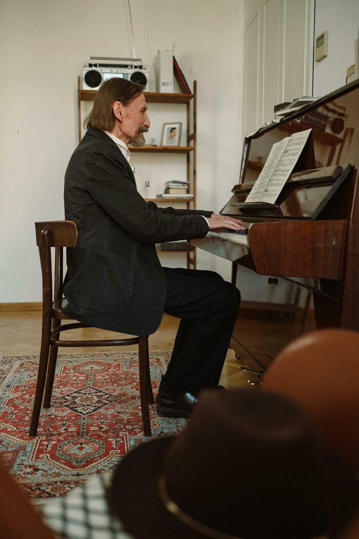 Elderly man playing piano, a family secret potentially hidden in the melodies.