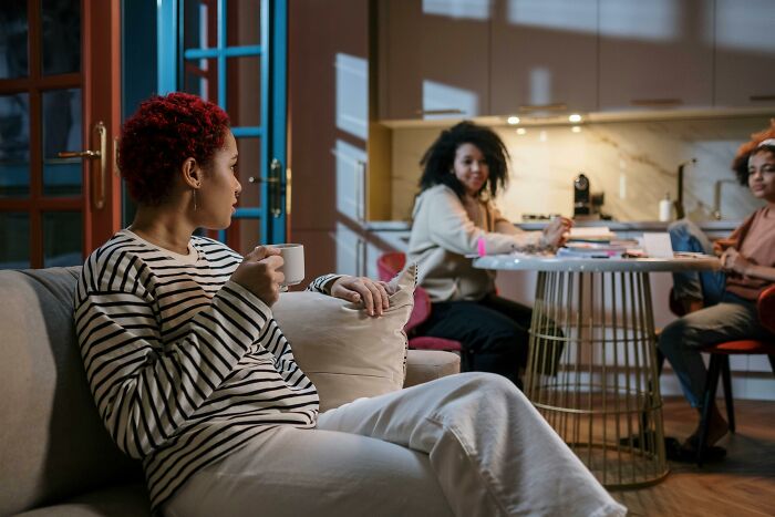 Three friends relaxing and chatting in a modern living room, illustrating urban legends unexpectedly true stories.