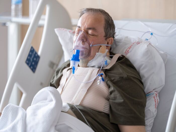 Elderly man in hospital bed with breathing mask, illustrating unexpected and bizarre ways people passed away.