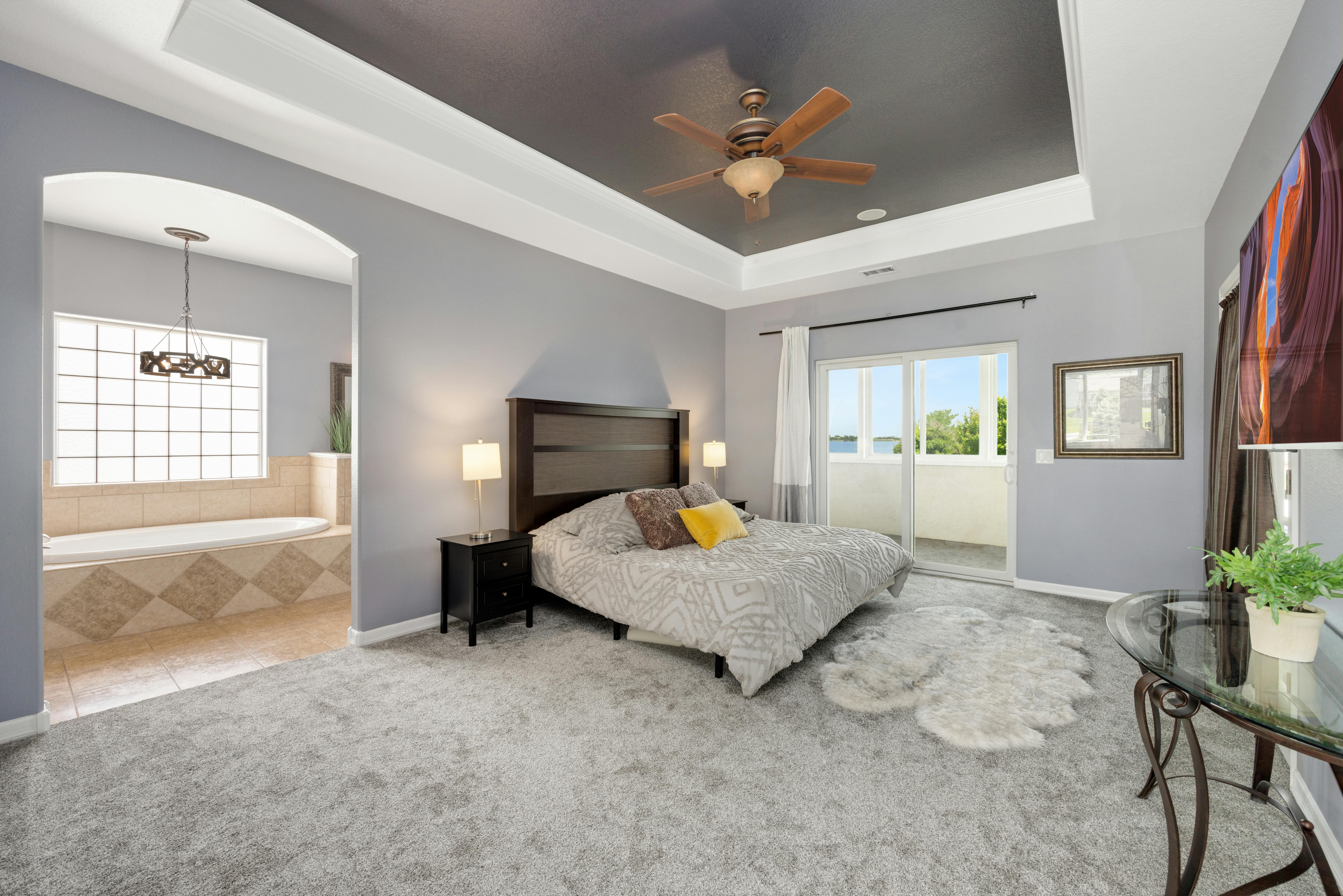 A spacious master bedroom with a king-sized bed, sliding doors to a balcony, and an adjacent bathroom with a tub. Social Dilemma Game.