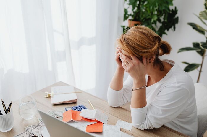 Woman stressed at desk with bills and calculator, illustrating terrifying statistics that might make it hard to sleep tonight.