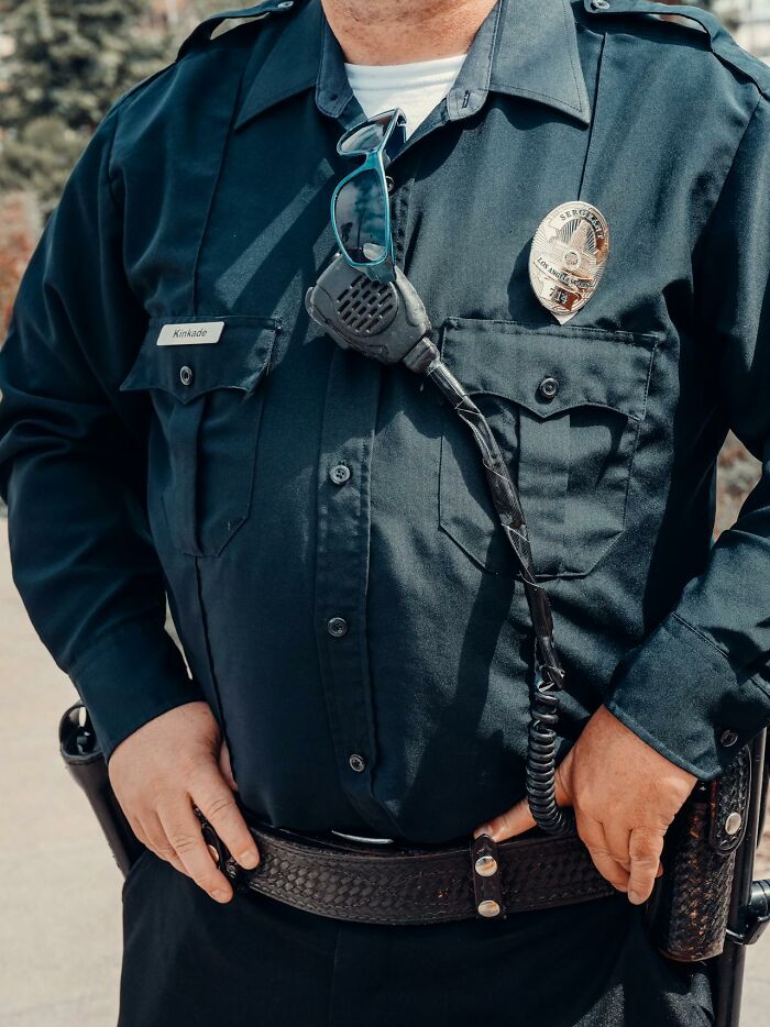 Police officer in uniform with radio and sunglasses attached, illustrating safety concerns in terrifying statistics.