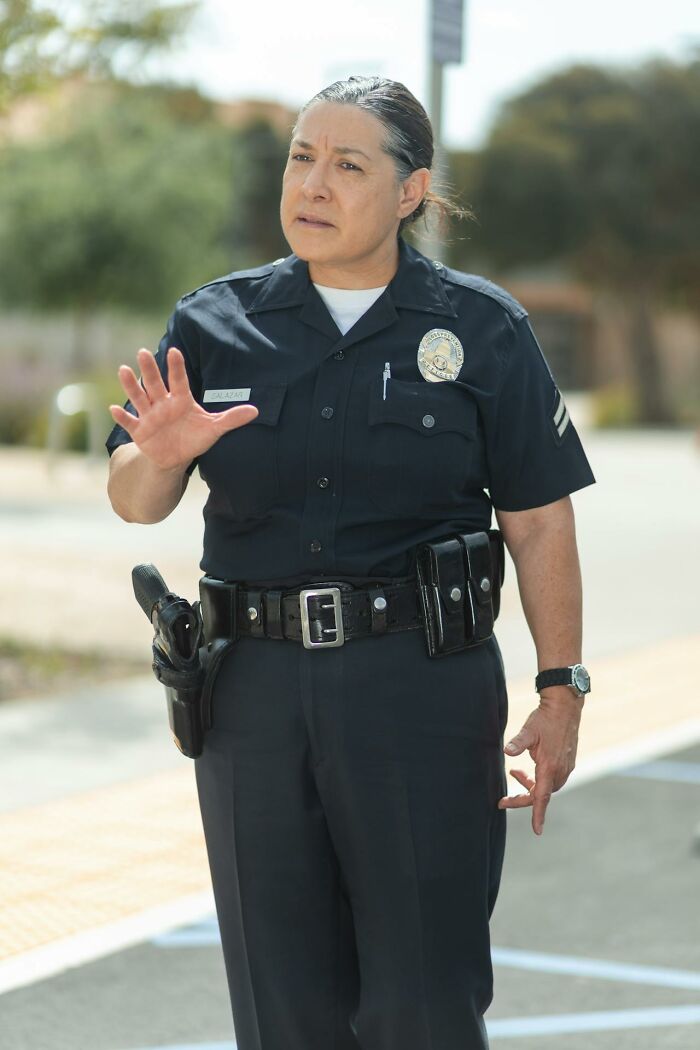 Female police officer in uniform using hand gestures, illustrating unexpected and bizarre ways people passed away.