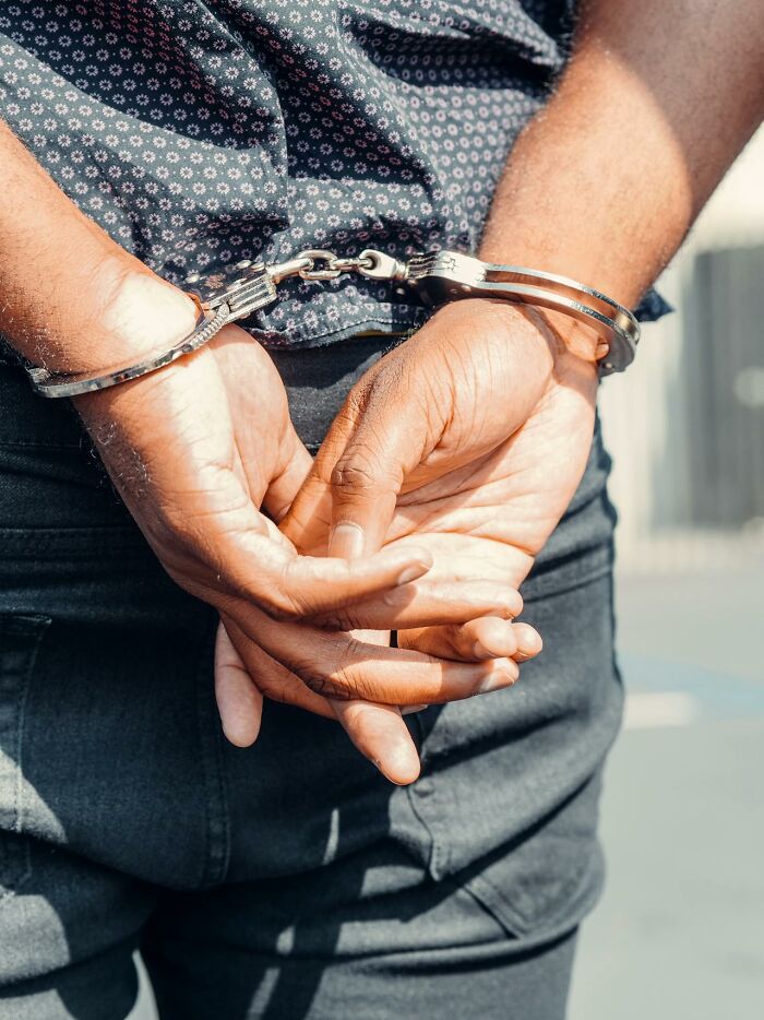 Close-up of a person in handcuffs with hands behind their back, illustrating intuition proved right consequences.