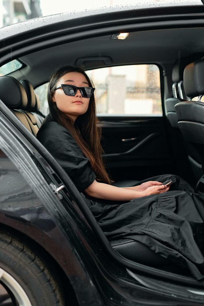 Young woman wearing sunglasses sitting in a car, reflecting on intuition being proved right for better or worse.