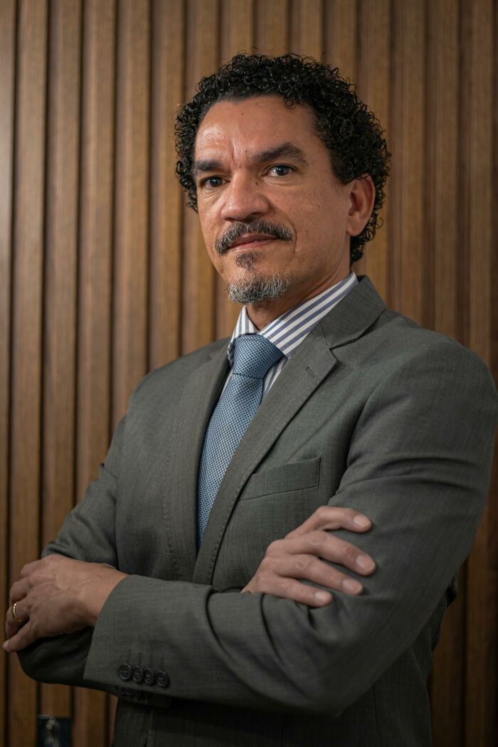 Professional man with arms crossed in gray suit and striped shirt, representing wild times employees deciding to quit job immediately.