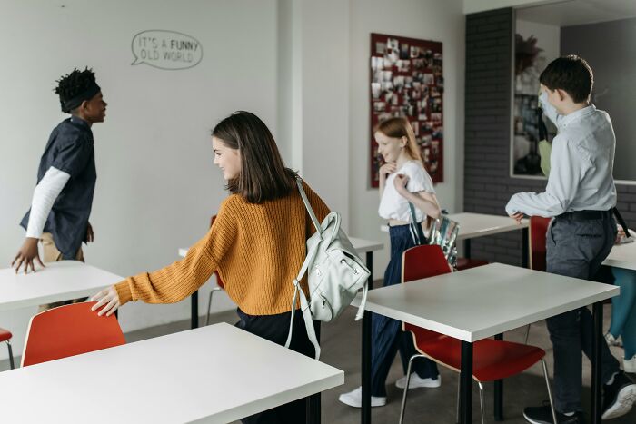 Students arranging chairs in a classroom preparing for a school trivia quiz with focus on school trivia quiz challenge.