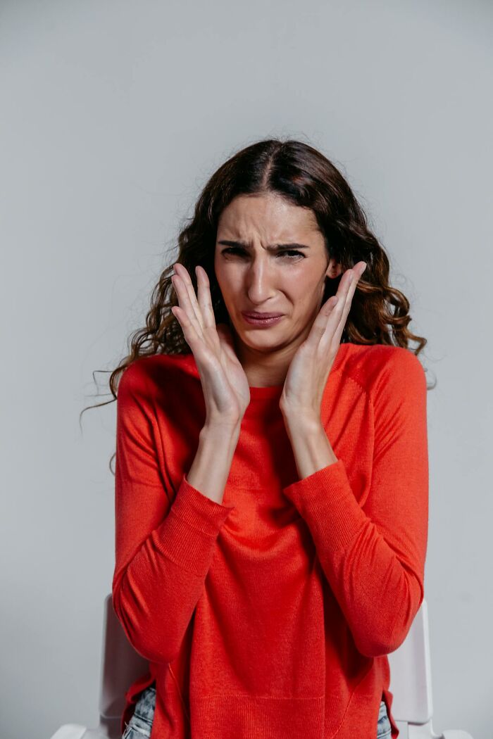 Woman in red sweater showing distress while reacting to dark family secrets she just figured out