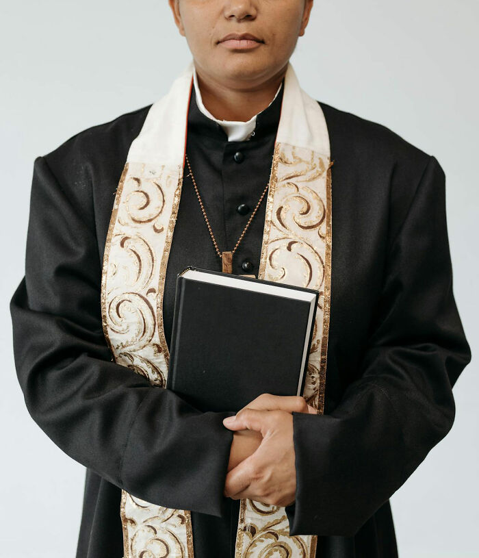 Religious figure in black robe holding a book, symbolizing intuition and faith being proved right in life stories.
