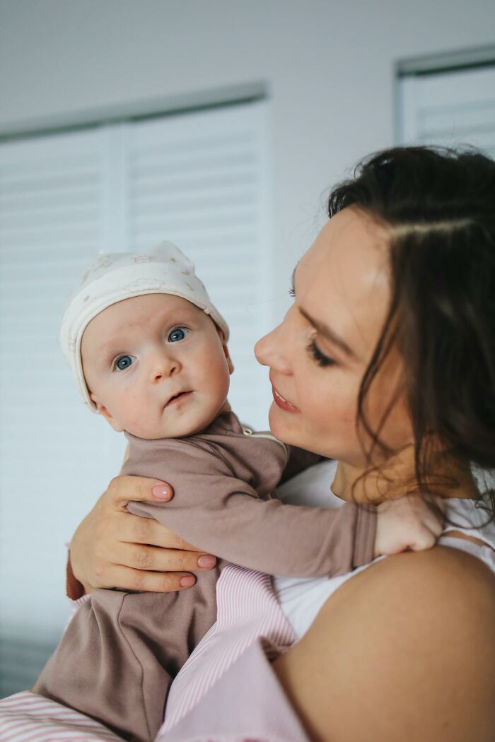 Mother holding baby close indoors, highlighting weird and interesting medical facts about early childhood health.
