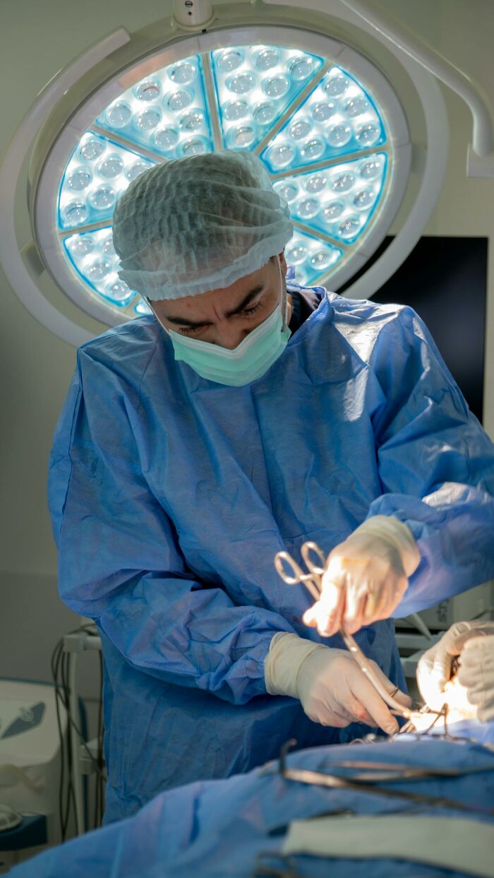 Surgeon in medical scrubs and mask performing surgery under bright operating room light medical facts