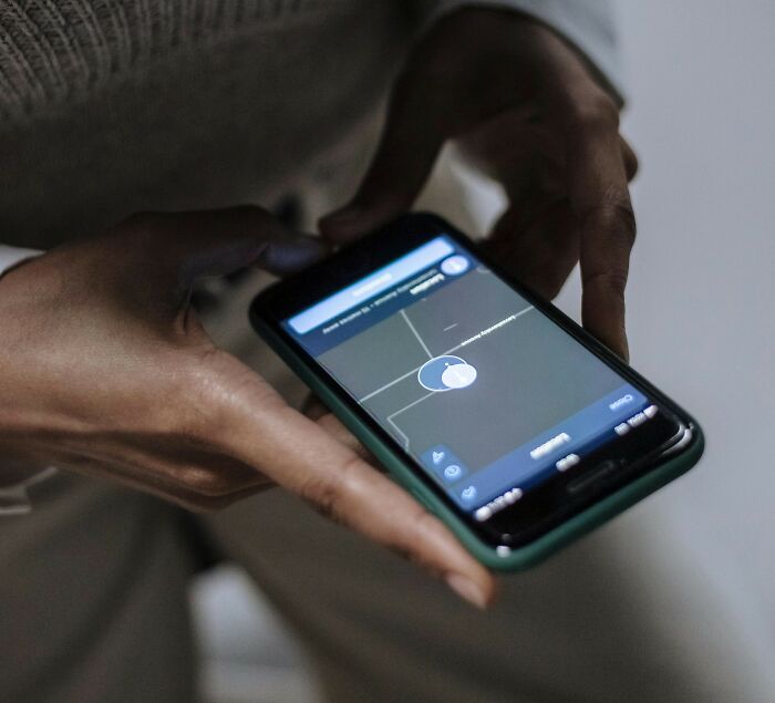 Hands holding a smartphone displaying a map application, symbolizing connectivity and shared experiences related to MIL stories.