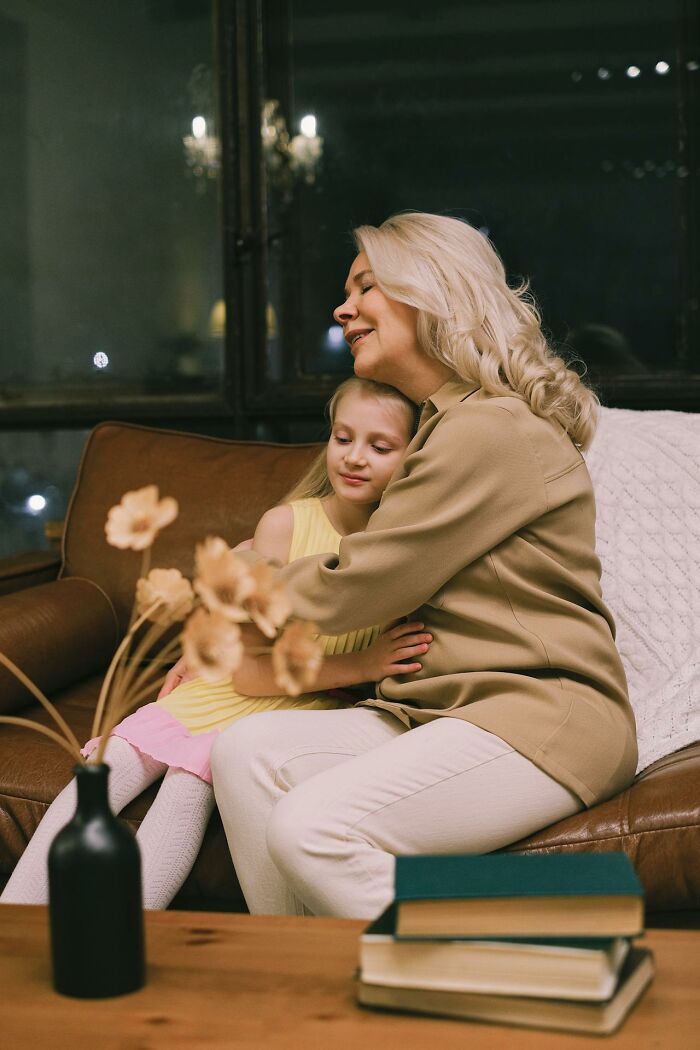 Woman and child sharing a tender moment on a couch, illustrating themes of dark family secrets and emotional discovery.