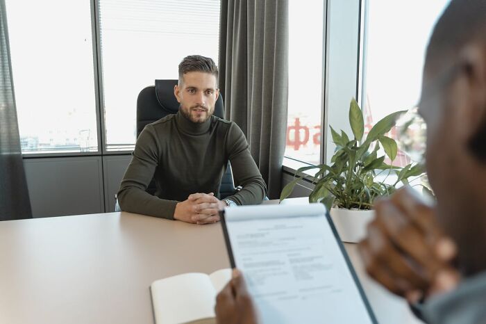 Man in a green sweater engaged in a conversation, illustrating people seeing their intuition being proved right.