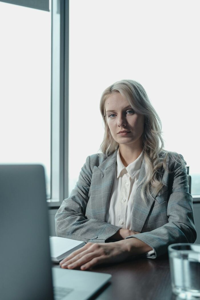 Businesswoman looking serious sitting by laptop in office, reflecting wild times employees decided to quit job immediately