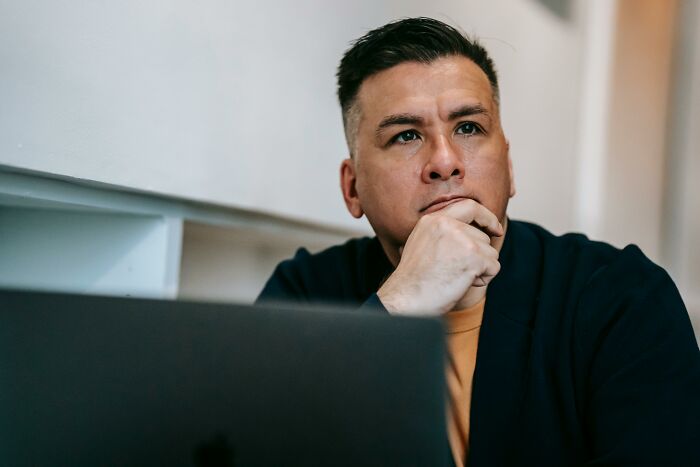 Man pondering, lost in thought. His expression suggests he's processing deep family secrets that shook him to the core.