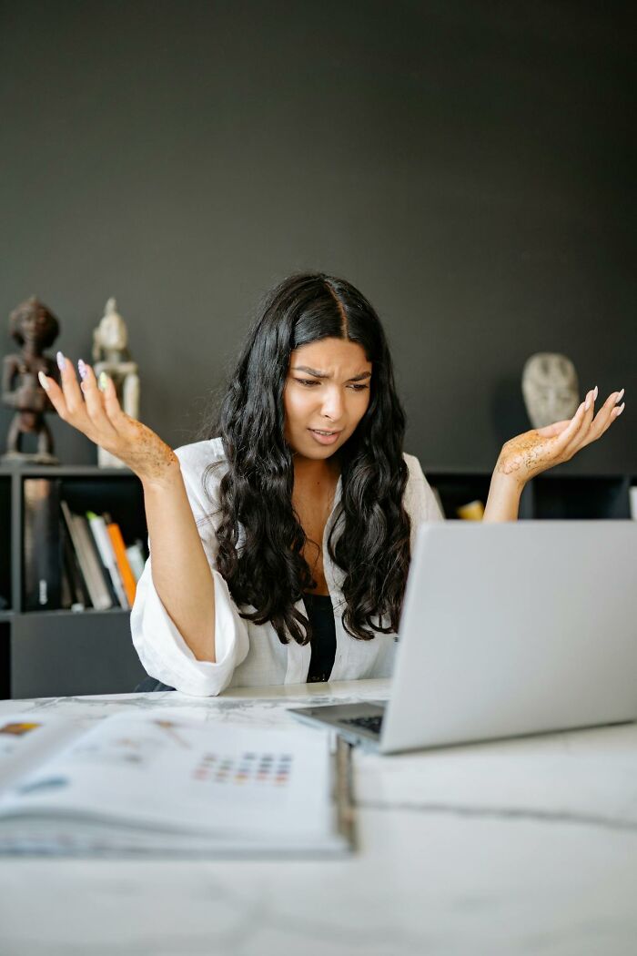 A frustrated employee raising hands in front of a laptop representing wild times employees quitting their job immediately.