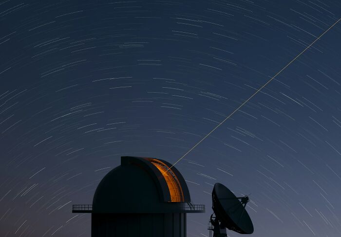 Night sky star trails over an observatory dome and satellite dish, symbolizing moments of good person betrayal and shock.