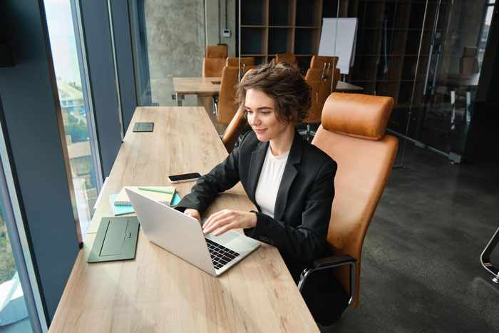 Woman working on laptop at office desk, illustrating workplace sabotage and project deletion without apology.