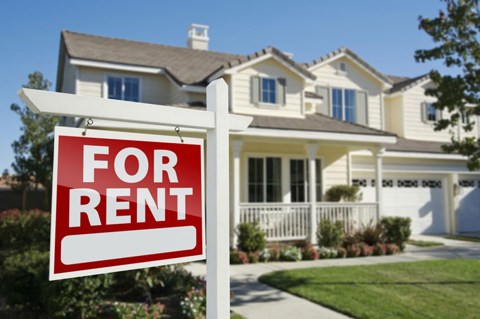A beige house with a "For Rent" sign in the foreground, signifying property decisions and potential conflict.