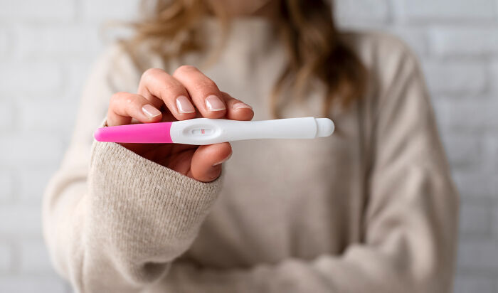 Person holding a positive pregnancy test during a psychic session, capturing a moment that defies explanation.
