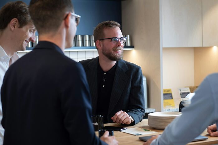 Group of professionals in a casual meeting, showcasing intelligence and collaboration in a modern office setting.