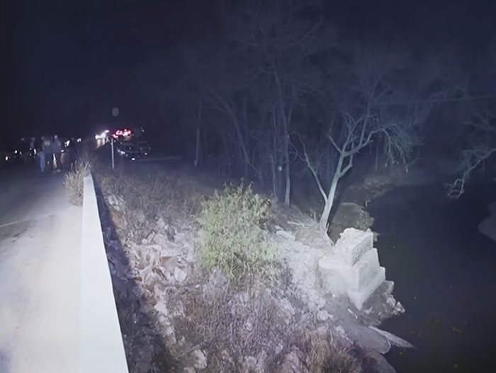 Nighttime scene near a riverbank with emergency vehicles and people, related to Athena Strand&rsquo;s mom and court dates.