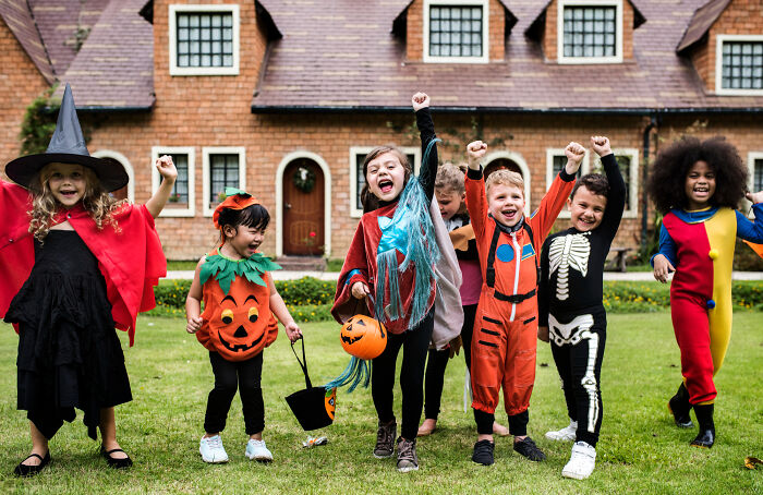 Diverse kids in Halloween costumes celebrating, demonstrating the absurd rules of childhood joy.