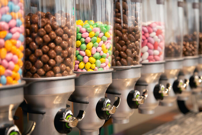 Candy dispensers in a row with various colorful sweets, illustrating absurd rules or choices in a fun way.