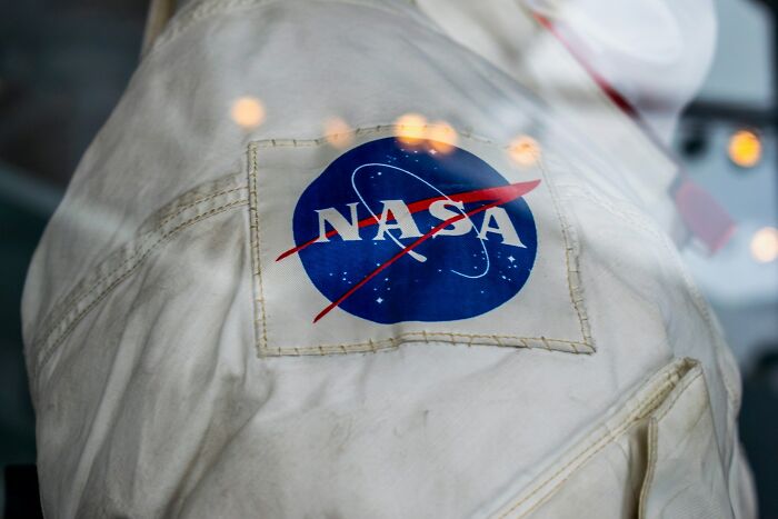 Close-up of a worn white suit featuring the NASA logo, symbolizing resilience and overcoming challenges of horrible bullies.