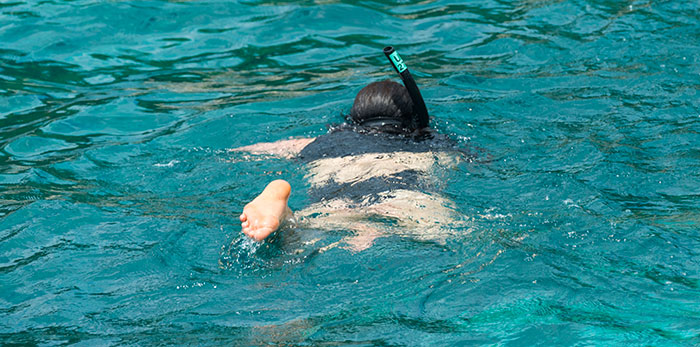 Person snorkeling in clear blue water. A scary experience can be an unexpected underwater encounter.