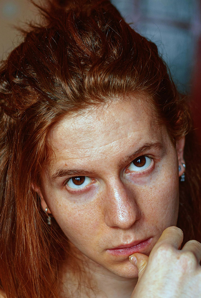 Close-up of a thoughtful person with red hair, representing kids in school who earned the weirdo title.